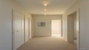 Monsoon dust footprints on light carpet in a bright modern Arizona entry — AZ Oriental Rug Cleaning style